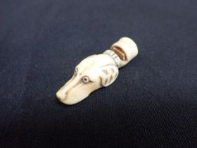 A CARVED BONE WHISTLE, IN THE FORM OF A DOG'S HEAD
