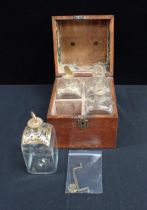 A SET OF FOUR GILDED GLASS DECANTERS, IN AN OAK CASE