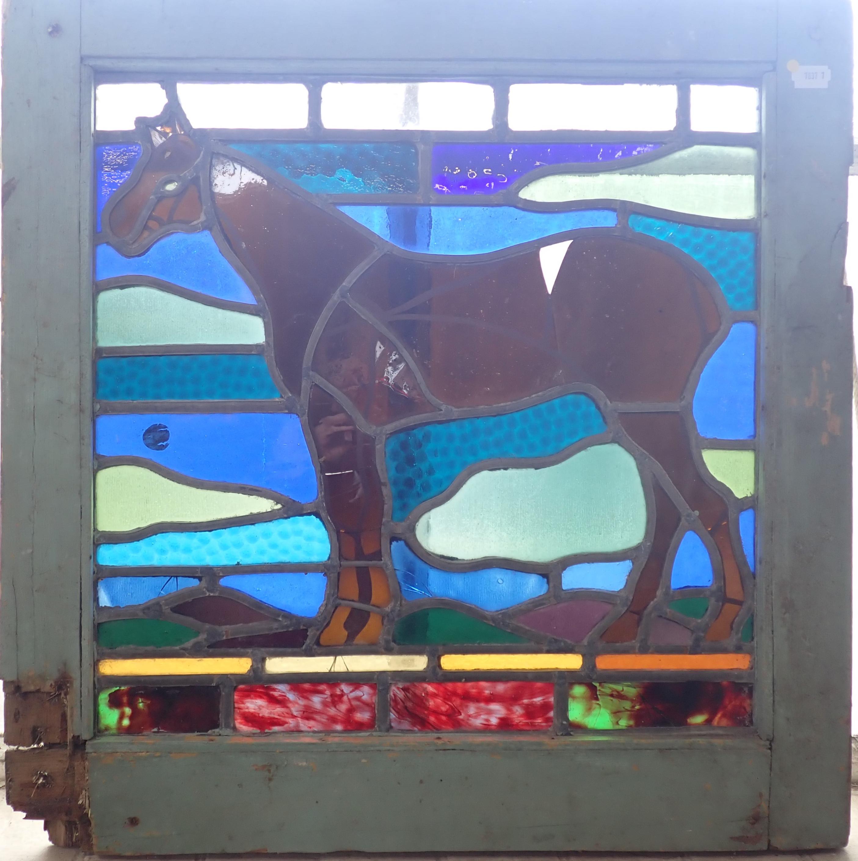 A LEADED COLOURED GLASS PANEL DEPICTING A HORSE