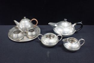 TWO SIMILAR PEWTER TEA SETS, WITH HAMMERED FINISH