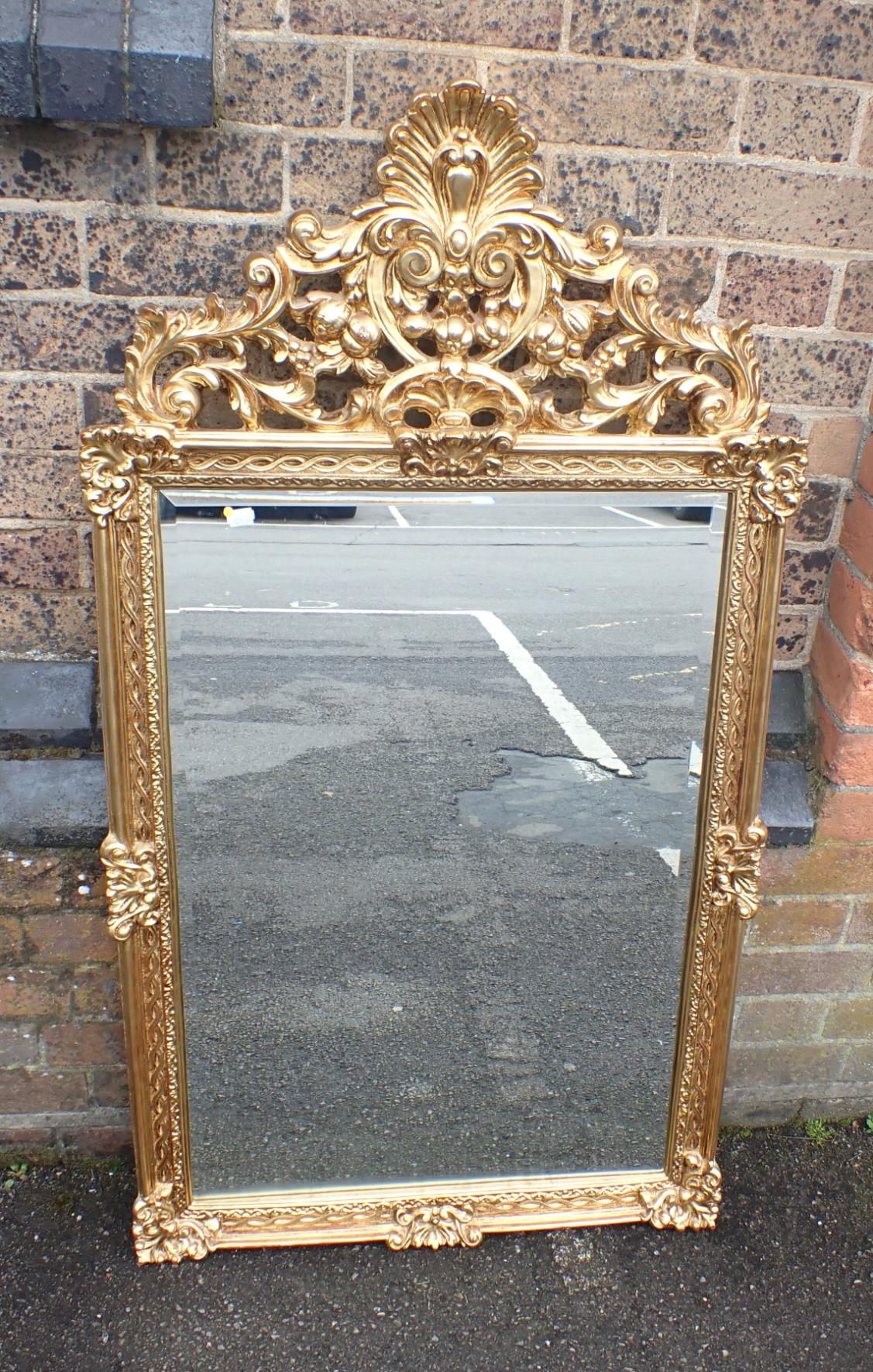 A GILT FRAME MIRROR WITH ROCOCO STYLE CREST
