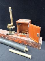 AN OLD BRASS MICROSCOPE ON IRON BASE