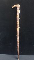 A FOLK ART WALKING STICK CARVED WITH ANIMALS