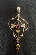 AN EDWARDIAN 9CT GOLD, GARNET AND SEED PEARL PENDANT