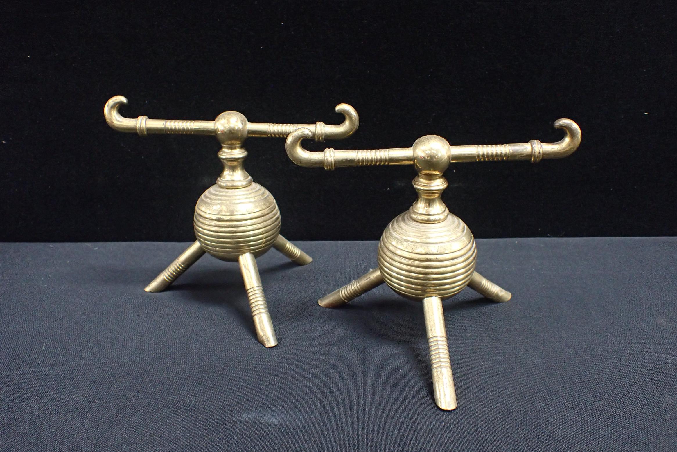 ATTRIBUTED TO DR CHRISTOPHER DRESSER: A PAIR OF BRASS FIRE DOGS
