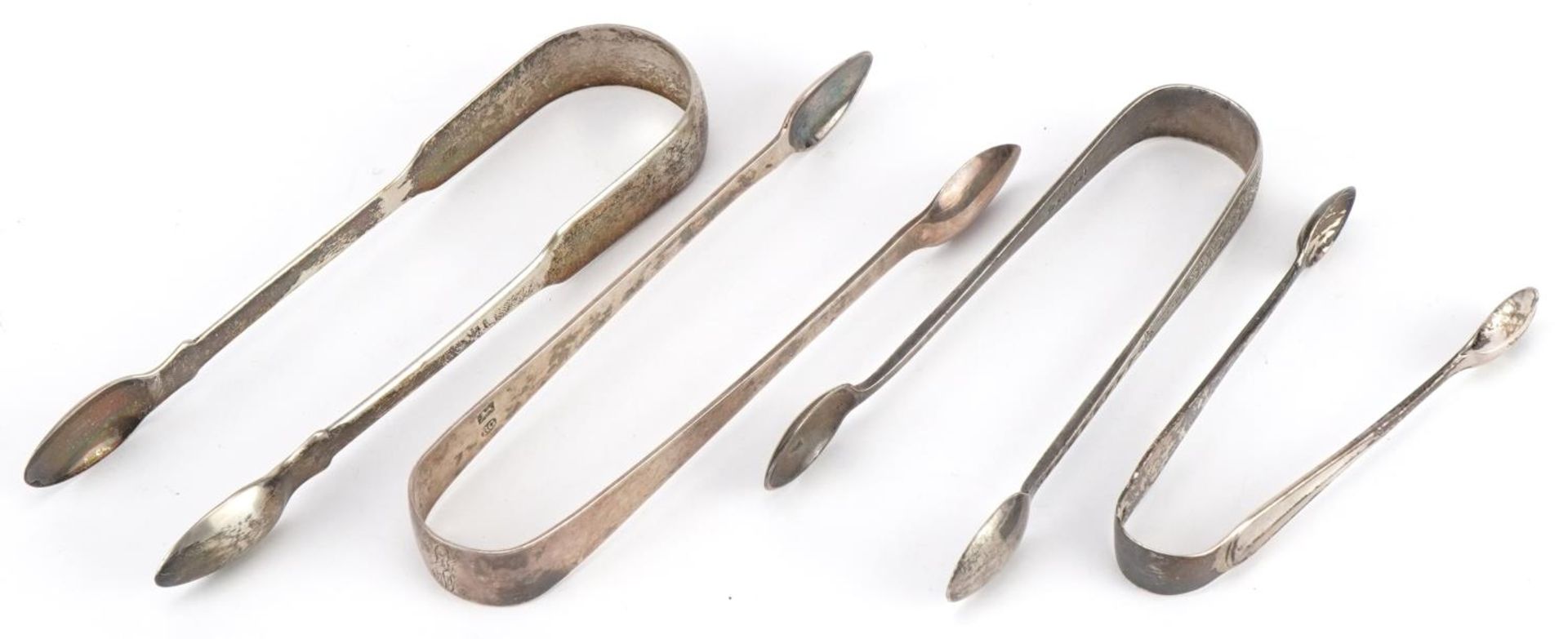 Four pairs of Georgian and later silver sugar tongs, the largest 14cm in length, total 114.6g :