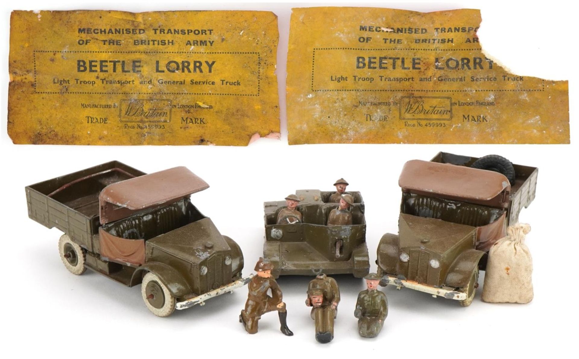 Two Britains hand painted lead military interest Beetle lorries and a Bren Gun carrier, with paper