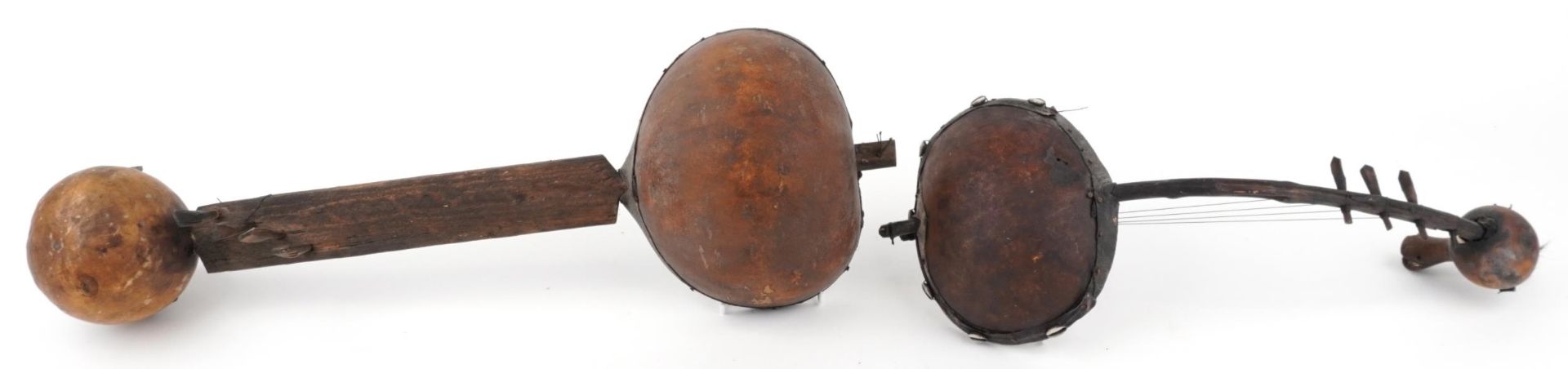 Two tribal interest African wooden animal hide musical instruments, the largest 68.5cm in length : - Image 3 of 3