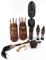 Tribal hardwood carvings including a large heavy figure of a mother with child and a carved bone