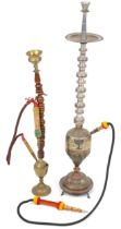 Two Islamic floor standing shisha pipes including a white metal example, the largest 118cm high :