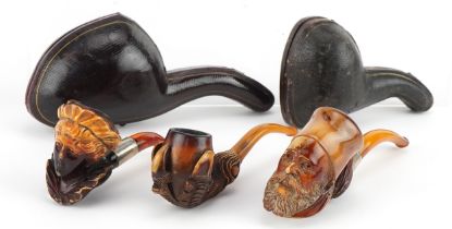 Three Meerschaum smoking pipes, two housed in velvet lined fitted cases, comprising bowls carved