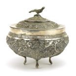 Chinese export unmarked silver four footed bowl and cover profusely embossed with birds amongst
