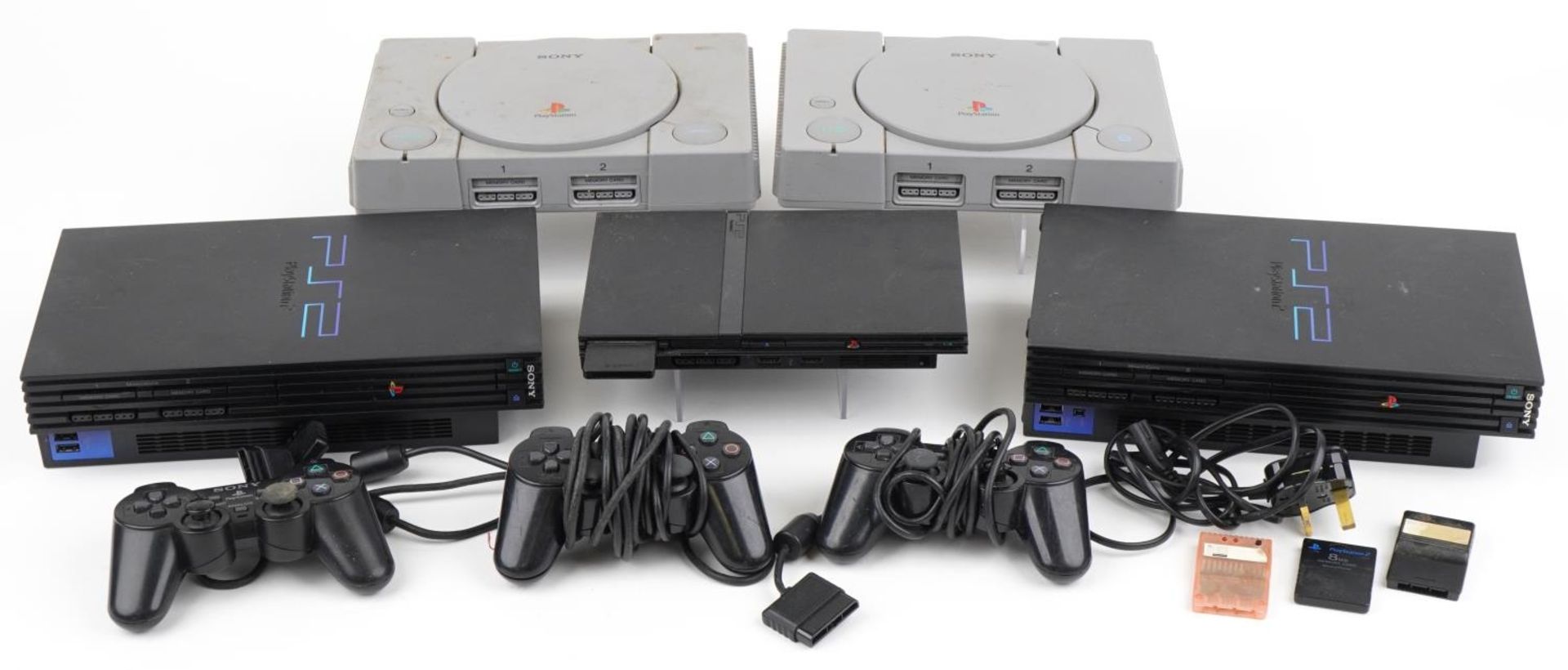 Five Sony games consoles with three controllers including two PlayStation 1s and three PlayStation