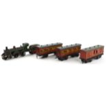 German tinplate O gauge railway GNR locomotive with tender and three first class carriages, the