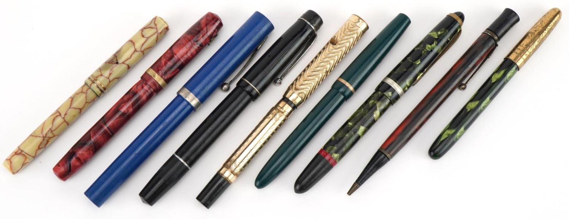Six vintage fountain pens and propelling pencils, two with gold nibs including a red marbleised