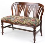 Stained wood two seater bench with floral upholstered seat on turned legs, 88cm H x 109cm W x 51.5cm