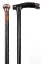 Two ebonised walking sticks with silver mounts and brass ferules, the largest 86cm in length : For
