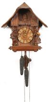 German Black Forest cuckoo clock carved with two figures having circular dial with Arabic