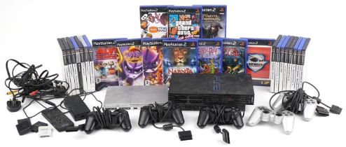 Two Sony PlayStation 2 games consoles with controllers and various games including Spiro and Grand