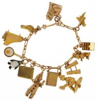 9ct gold charm bracelet with a selection of mostly gold charms including articulated clown, pixie on