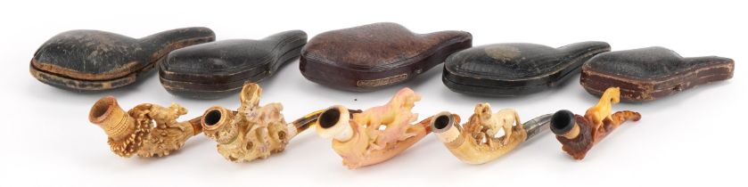 Five antique Meerschaum smoking pipes housed in fitted cases, each carved with animals, four with