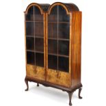 Regency style double dome burr walnut bookcase with glazed doors enclosing three shelves, 178cm H