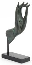 Thai verdigris patinated bronze hand raised on an ebonised stand, overall 32.5cm high : For