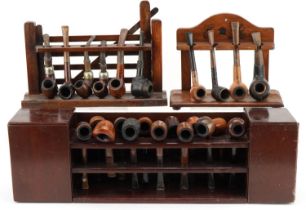 Twenty three vintage tobacco smoking pipes, predominantly briar, arranged in three pipe racks