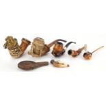 Six antique Meerschaum smoking pipes including three carved with hands, one carved with a wild