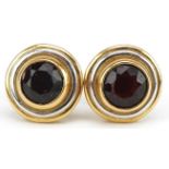 Pair of two tone gold garnet solitaire stud earrings, the backs marked 750, 13mm in diameter, 7.7g :
