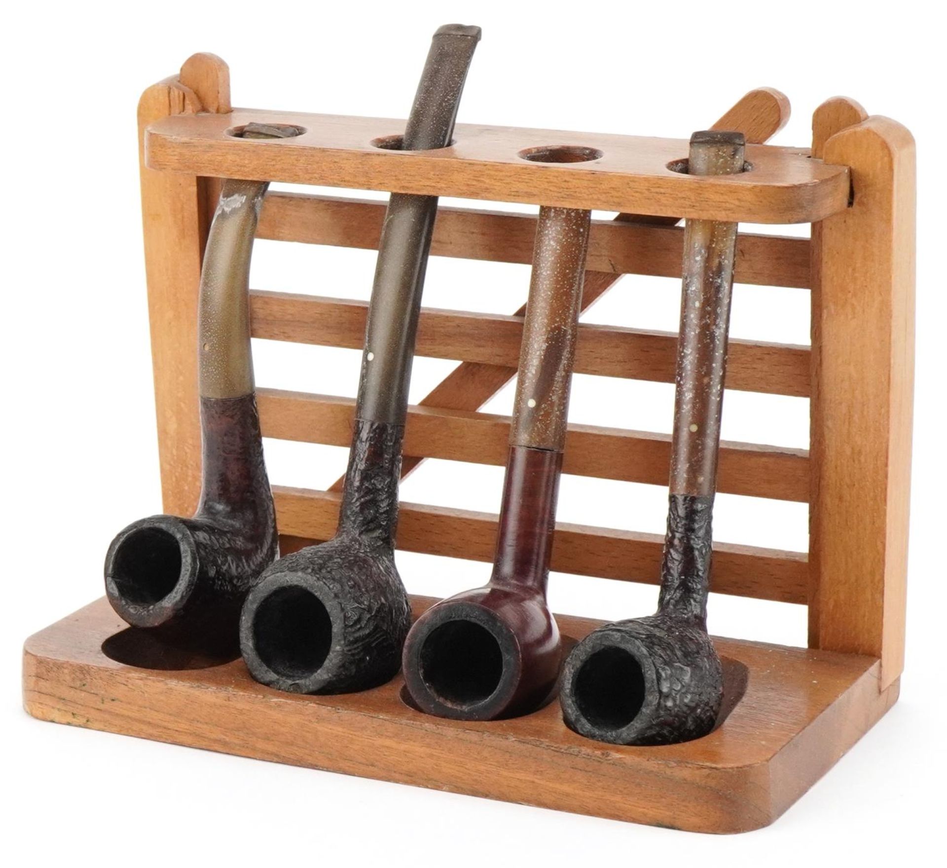 Four Dunhill briar tobacco smoking pipes arranged in a gate design pipe rack including Shell