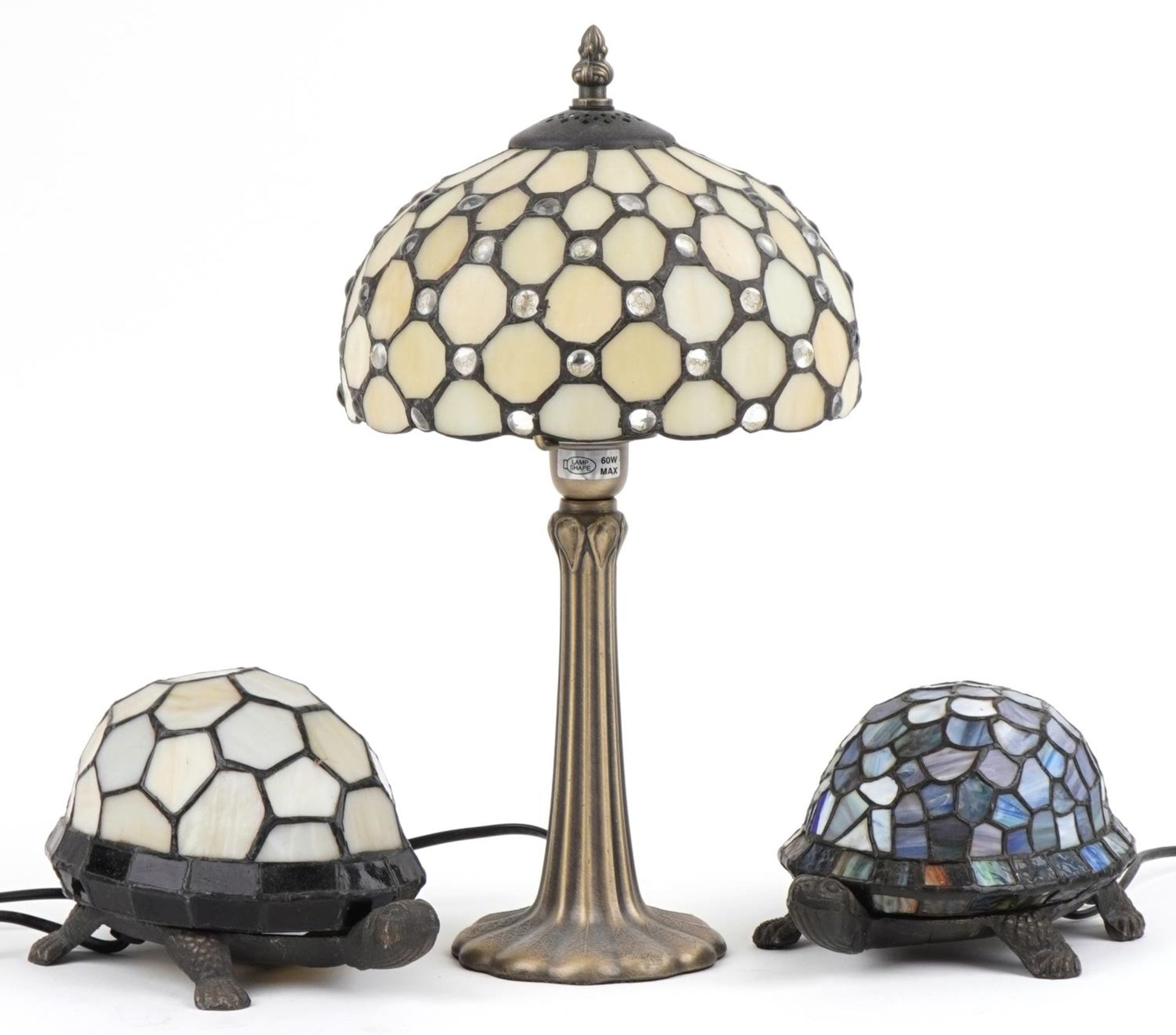 Three Tiffany design table lamps including two bronzed examples in the form of tortoises, the