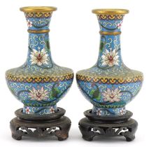 Pair of Chinese cloisonne vases raised on hardwood stands enamelled with flowers amongst scrolling