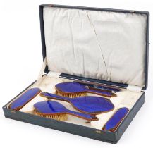 Early 20th century brass blue guilloche and black enamel foliate dressing table set with fitted case