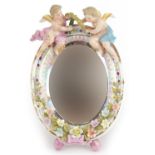Sitzendorf, German porcelain oval easel floral encrusted mirror having bevelled glass surmounted