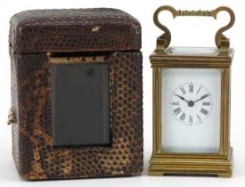 Miniature brass cased carriage clock with case, the circular dial having Roman numerals, the