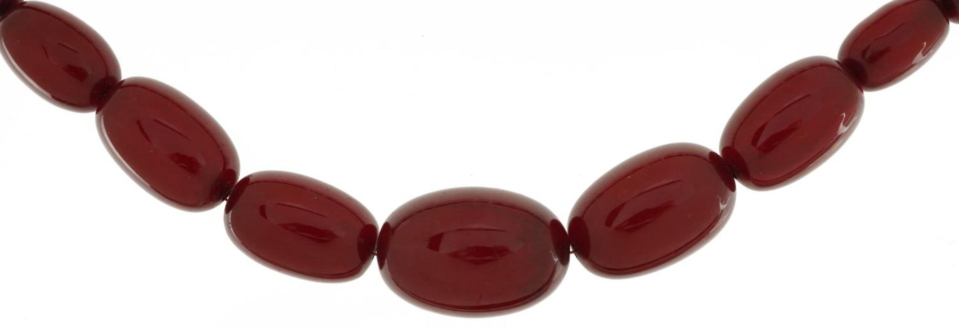 Cherry amber coloured bead necklace, the largest bead approximately 25.5mm x 17mm in diameter,