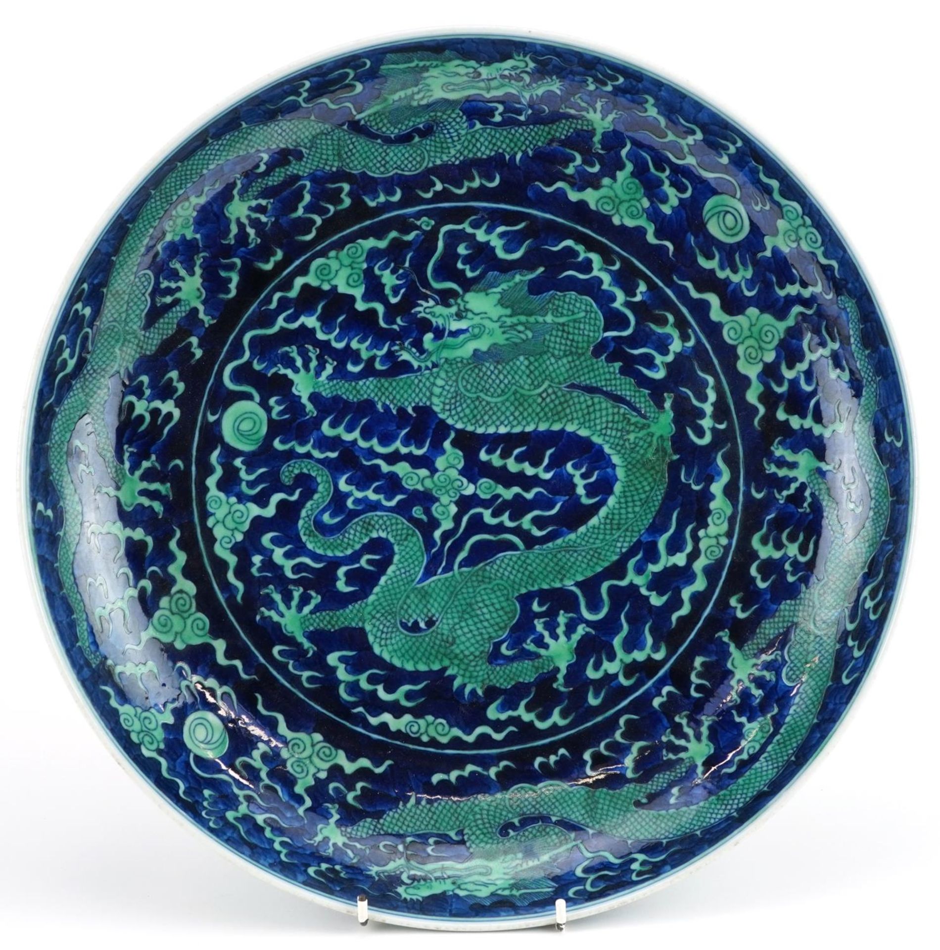 Large Chinese porcelain blue ground charger hand painted with dragons chasing the flaming pearl