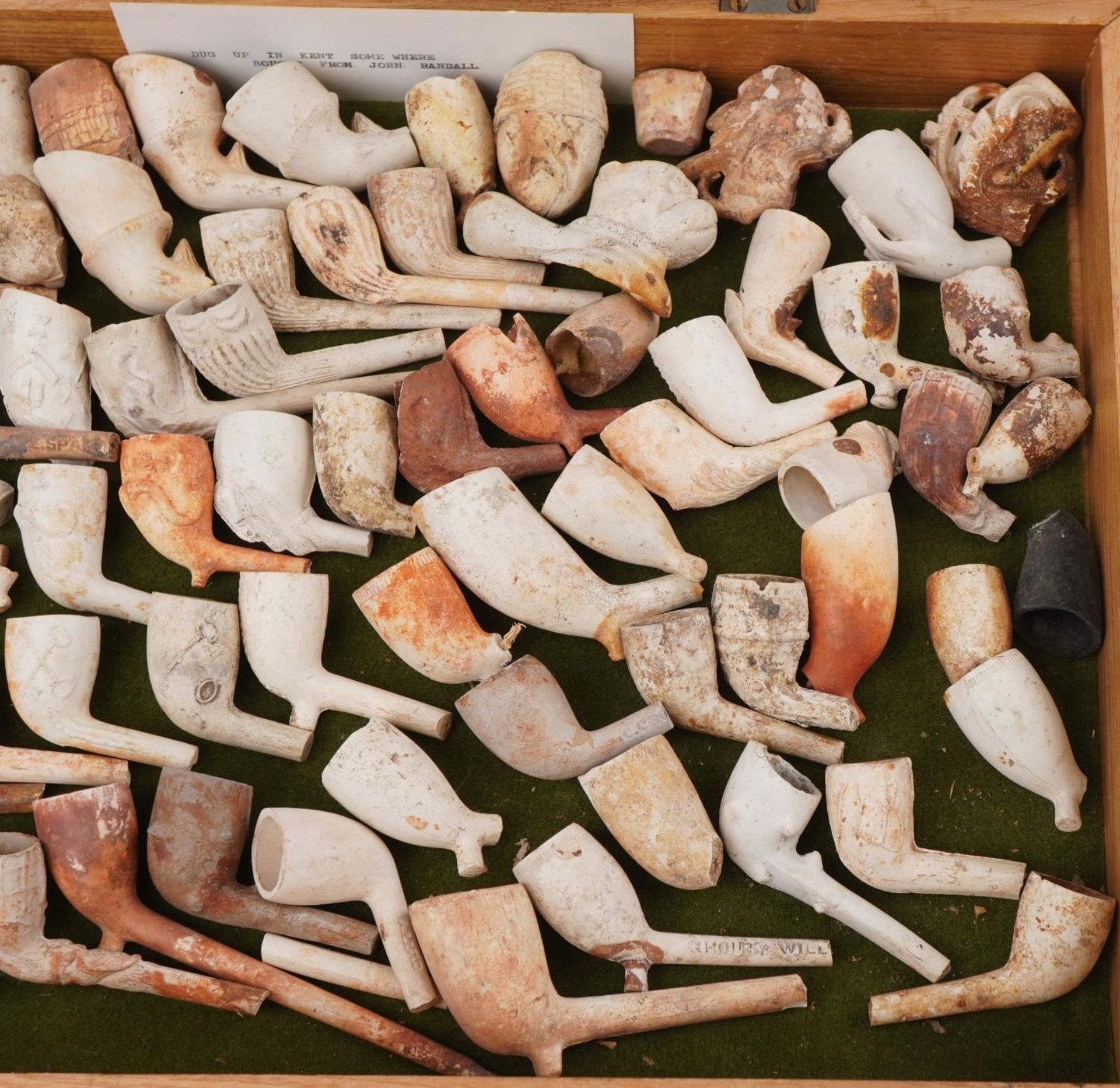 Large collection of antique clay tobacco smoking pipes and bowls arranged in a glazed display case - Bild 4 aus 5