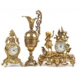 Two French Rococo style mantle clocks and a large brass ewer with C scroll decoration, the largest