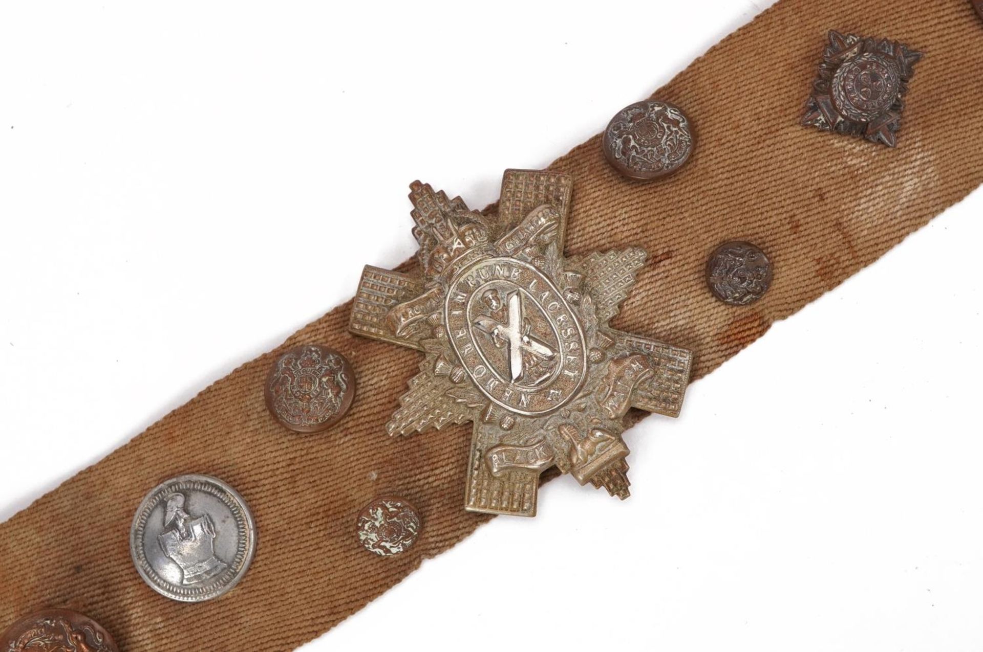 Military interest canvas belt with various cap badges and buttons including East Yorkshire and