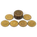 Six antique gilt metal tokens commemorating naval victories housed in a cylindrical pot with pierced