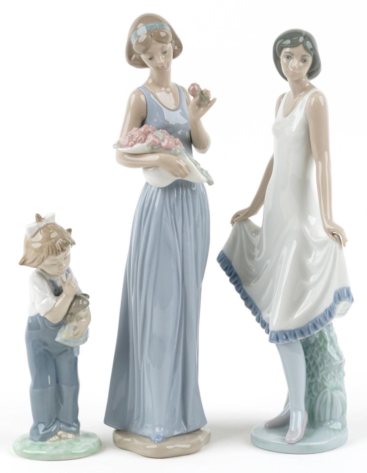 Three Nao figurines including one of a female holding a basket of flowers, the largest 32cm high :