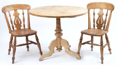 Victorian stripped pine circular dining table and two chairs, the table 76cm high x 94cm in diameter