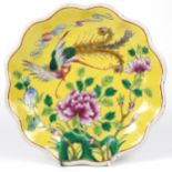 Chinese porcelain footed yellow ground dish hand painted in the famille rose palette with a