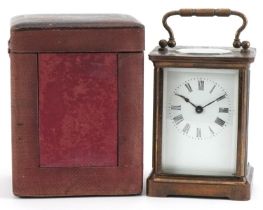 French brass cased carriage clock with enamelled dial having Roman numerals and travel case, 11cm