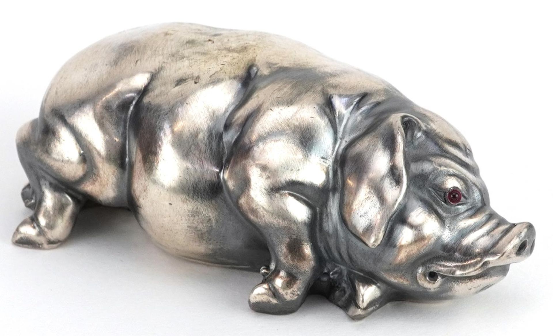 Silver recumbent pig with cabochon ruby eyes, impressed Russian marks to the base, 7cm in length,