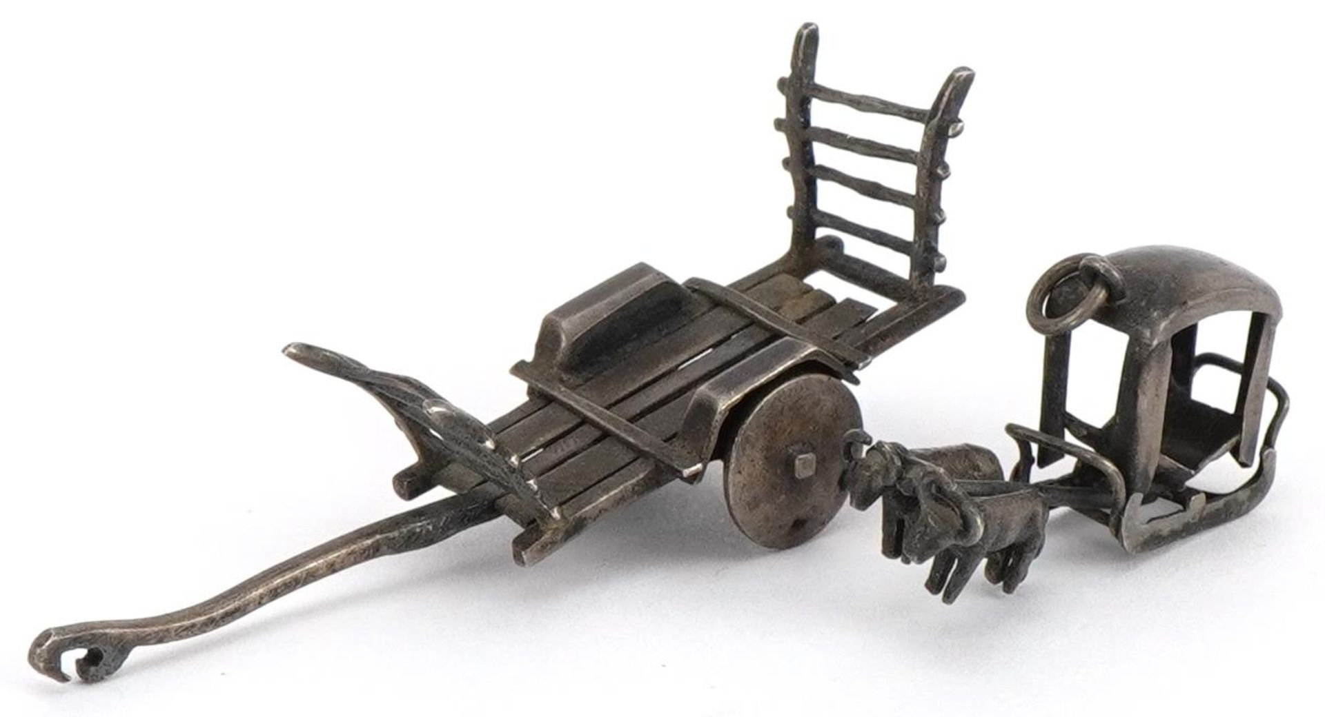 Asian unmarked silver miniature cart and a buffalo drawn cart charm, the largest 5.5cm in length,