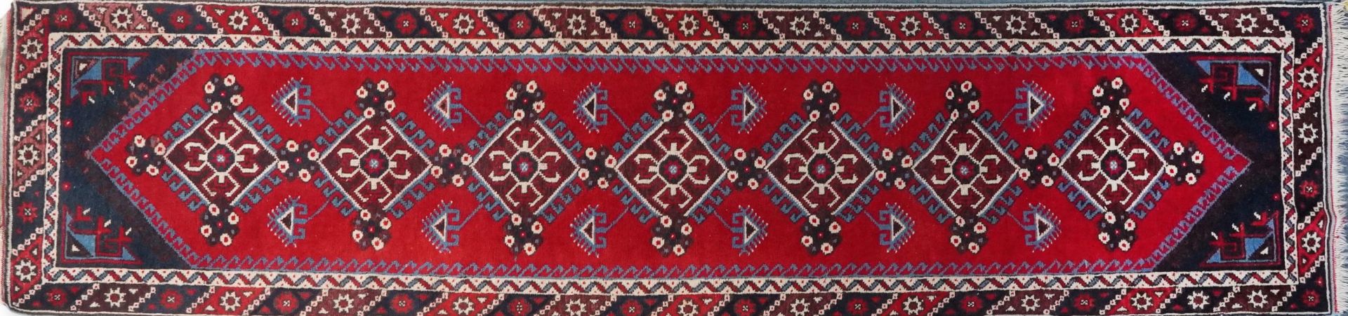 Turkish Red and blue ground carpet runner having an allover repeat geometric design, 295cm x
