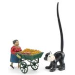 Vintage clockwork street trader and a novelty porcelain monkey with wagging tail, the largest 24cm